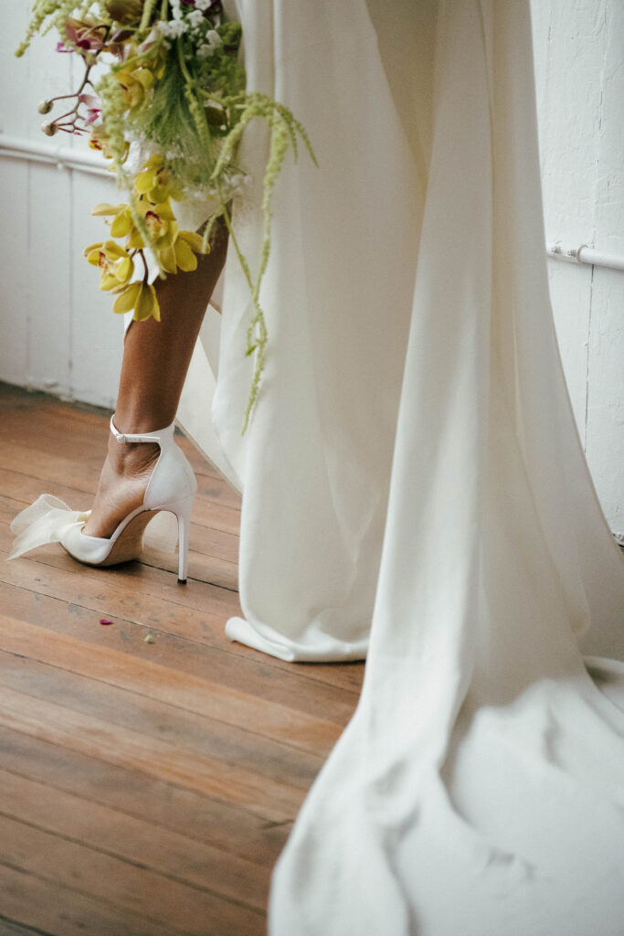 Close-up of embellished bridal heels on a rustic wood floor, perfect for a luxury bridal session."