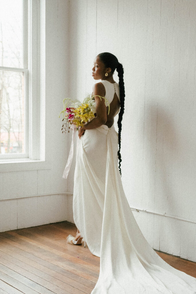 Bride holding a bold yellow bouquet paired with an OUMA gown during a pre-wedding bridal session.