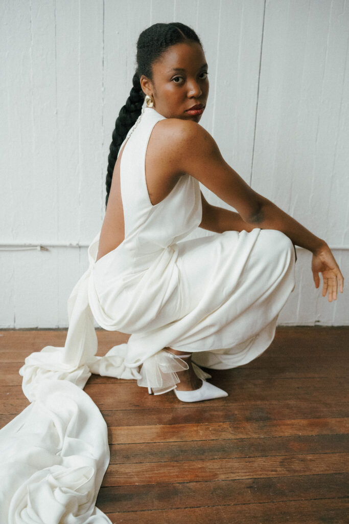 Bride in an OUMA Bridal gown with a dramatic train captured in natural light during a pre-wedding photoshoot