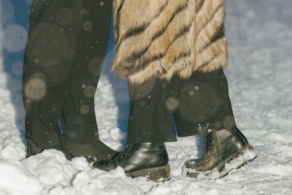 Romantic engagement photo with snow falling in Vancouver park couples doc martin boots